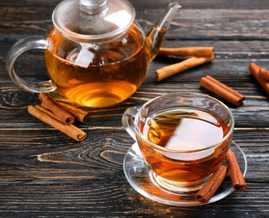 Cup and teapot with aromatic hot cinnamon tea on wooden table; Shutterstock ID 696392743; Job (TFH, TOH, RD, BNB, CWM, CM): TOH